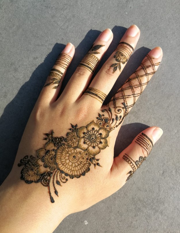 A delicate small aesthetic henna design wrapping around a wrist.