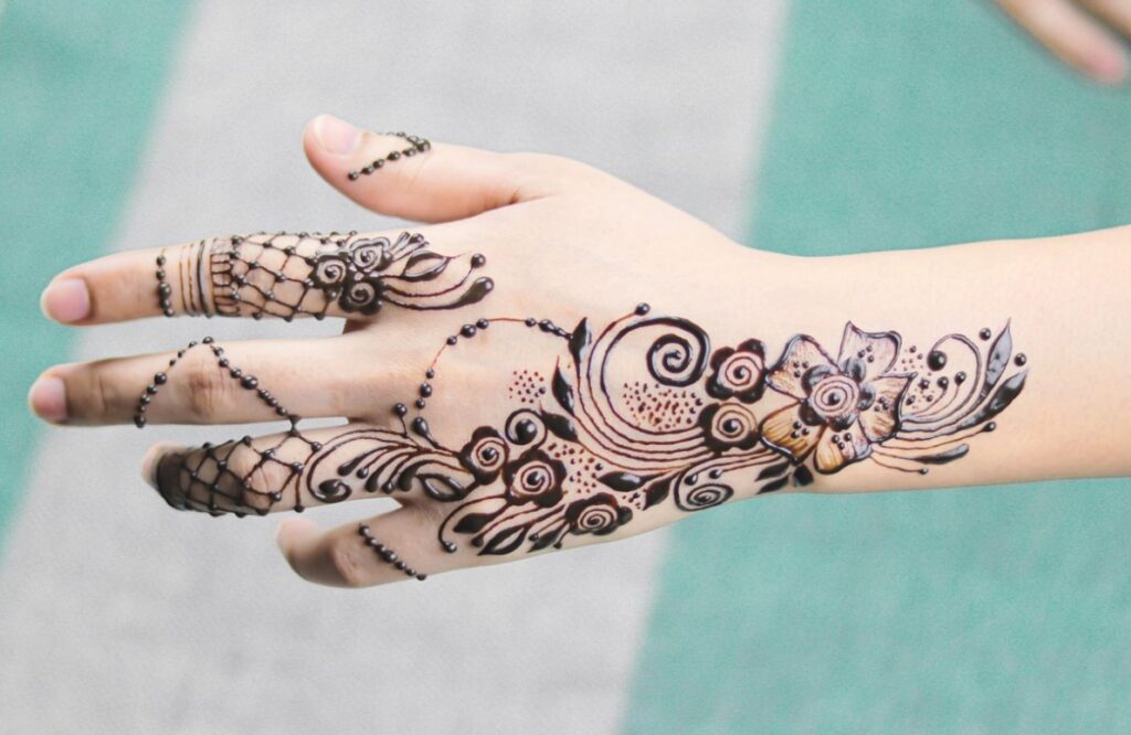 A delicate small aesthetic henna design wrapping around a wrist.