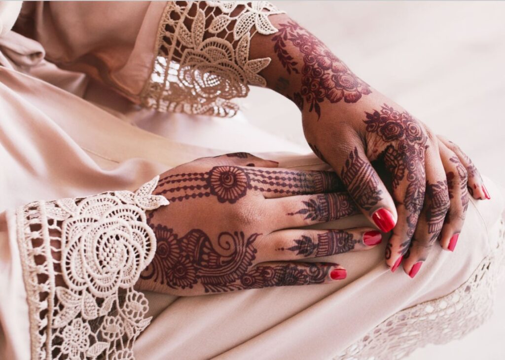 A delicate small aesthetic henna design wrapping around a wrist.